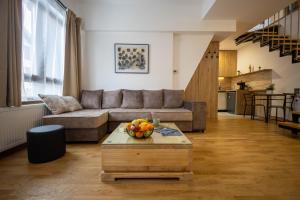 a living room with a couch and a table with a bowl of fruit at Apartmani RAZVIGORA - DivčiNova in Divčibare