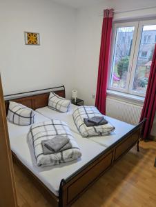 1 Schlafzimmer mit 2 Betten mit Kissen und einem Fenster in der Unterkunft Bahnhotel Dippoldiswalde in Dippoldiswalde