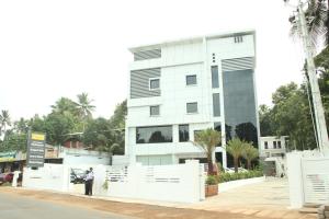 a man standing in front of a white building at Hotel Hills Park in Pathanāmthitta