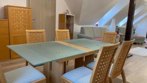 comedor con mesa azul y sillas en Buongiorno Apartman, en Szálka
