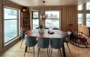 a dining room with a wooden table and chairs at Awesome Home In Flesberg With Wifi in Lampeland