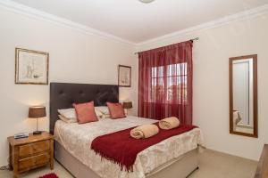 カルヴォエイロにあるCarvoeiro 8Aのベッドルーム1室(赤いカーテン付きの大型ベッド1台付)