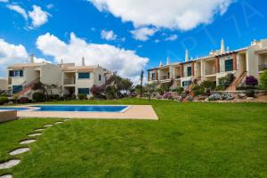 a villa with a swimming pool and a lawn at Carvoeiro Apartment 7A in Carvoeiro