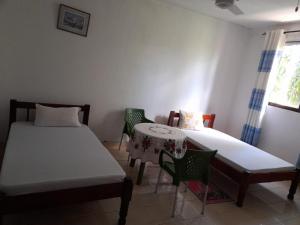 een kamer met 2 bedden en een tafel en stoelen bij ZARADISE SUITES HOTEL, MOMBASA KENYA in Mombasa