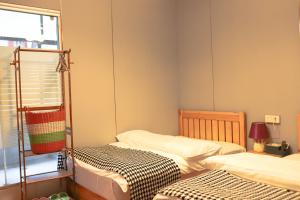 a small room with two beds and a window at Changsha Fuxiangyuan International Hostel in Changsha