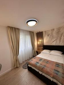 um quarto com uma cama e uma grande janela em ApartHotel Tarnaveni em Tîrnăveni