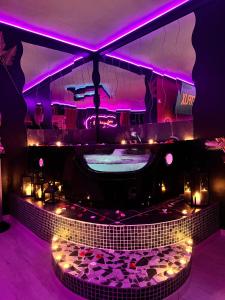 a nightclub with purple lighting and a stage at LoveRoom by Sunnyroom in Perpignan