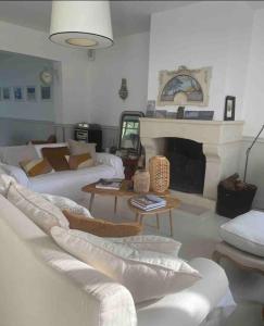 a living room with white furniture and a fireplace at Deauville. Grande villa, plage. in Tourgeville