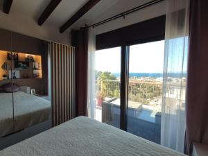 um quarto com uma cama e uma grande janela de vidro em THEASIS Luxury Panoramic Penthouse em Neos Marmaras