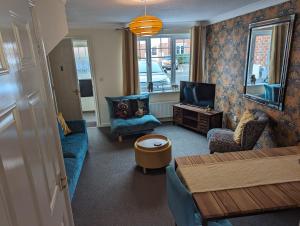 ein Wohnzimmer mit Sofa, Sesseln und Fernseher in der Unterkunft Modern 3 bedroom home *EVcharging* Garden, Parking in Darlington