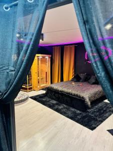 a bed in a room with purple walls and curtains at LoveRoom by Sunnyroom in Perpignan