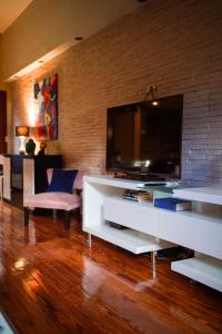 a living room with a television on a white entertainment center at Casa MUKAU Buenos Aires in Buenos Aires +17 photos