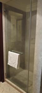 a glass shower with a white towel on a towel rack at MARIGOLD APARTMENT At TIMES SQUARE in Kuala Lumpur