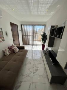 ein Wohnzimmer mit einem Sofa und einem Tisch in der Unterkunft 2 Bedroom Apartment in Msida, Malta in Msida