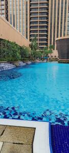 a large swimming pool in a city with tall buildings at KL MARIGOLD APARTMENT At TIMES SQUARE in Kuala Lumpur