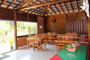 uma sala de jantar com mesas e cadeiras de madeira em Vila Mantilla Pousada em Três Marias