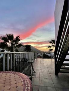 einen Balkon mit einem Tisch und Stühlen sowie einem Sonnenuntergang in der Unterkunft Casa Cocolores in Villaverde