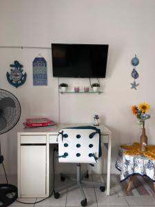 a desk with a chair and a television on a wall at Pirata Family House• A 5 min de Poblado Boquerón in Cabo Rojo