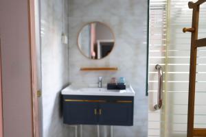 a bathroom with a sink and a mirror at Changsha Fuxiangyuan International Hostel in Changsha