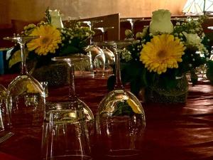una mesa con copas de vino y flores. en Hotel La Piazzetta, en Vidiciatico