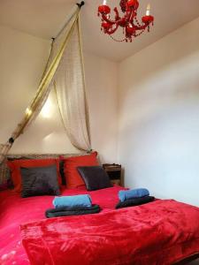 a red bed with two pillows on top of it at T2 centre village "Chez Clothilde" in Remoulins