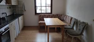 cocina con mesa de madera y sofá en Käfer e, en Waldbrunn