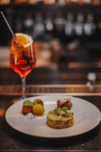 a white plate with food and a drink on a table at La Griffe Hotel Roma in Rome