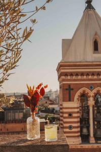 a vase of flowers sitting on a table with a building at La Griffe Hotel Roma in Rome