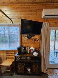 a living room with a television on a wall with a table at Honey Bear Haven Suite 5 in Eureka Springs