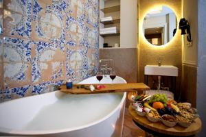 uma casa de banho com uma banheira com uma taça de frutas e copos de vinho em Ayramin Exclusive Hotel - Special Category em Istambul