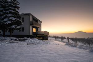 ein Haus im Schnee mit Sonnenuntergang im Hintergrund in der Unterkunft Owocowe Wzgórze in Tęgoborze