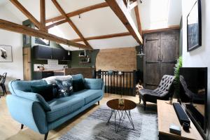a living room with a blue couch and a table at A countryside retreat in Chipping Norton