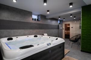 a large white bath tub in a room with a table at Owocowe Wzgórze in Tęgoborze
