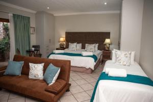 a hotel room with two beds and a couch at Bluewater Reservations in Port Elizabeth