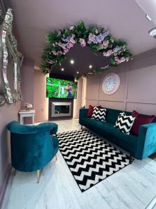 a living room with a blue couch and a tv at The Ultimate Hen Suite with Bar & Makeup Room in Manchester