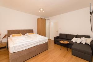 a bedroom with a bed and a couch at Holiday Home Malačnica in Supetar