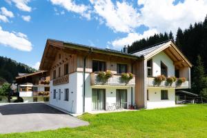 een gebouw met bloemen op de balkons op een grasveld bij Appartements Salitererhof in Saalbach Hinterglemm