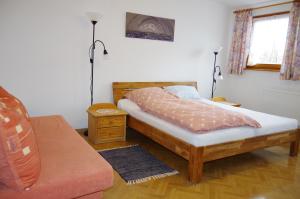 ein Schlafzimmer mit einem Bett und einem Sofa in der Unterkunft Appartement Fleischmann in Kirchröttenbach