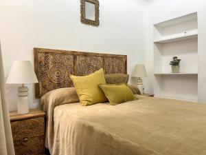 マラガにあるApartamentos Málaga centroのベッドルーム1室(大型ベッド1台、黄色い枕付)