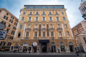 un gran edificio amarillo en una calle de la ciudad en La Griffe Hotel Roma en Roma