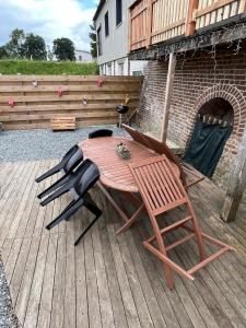 een houten tafel en 2 stoelen op een patio bij Appartement atypique in Eslettes