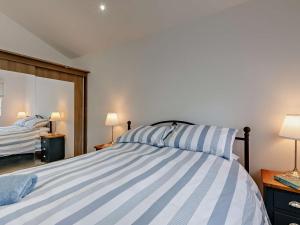 a bedroom with a bed with blue and white stripes at 2 Bed in Brixham 90912 in Brixham