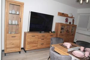 a dining room with a table with chairs and a television at apartament 1000-lecia in Wąbrzeźno