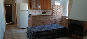 a kitchen with a white refrigerator and a brick wall at San Luis A 4 del mar Centrica in San Luis