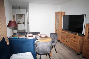 a living room with a table with chairs and a television at apartament 1000-lecia in Wąbrzeźno