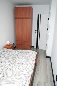 a bedroom with a bed and a wooden door at apartament 1000-lecia in Wąbrzeźno