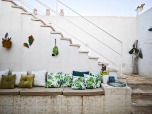 a couch with pillows on it next to stairs at Paradise Sea Terrace in Monopoli