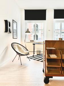 - un salon avec une chaise et une table dans l'établissement MAKERS + ROOMS APARTMENTS, à Detmold