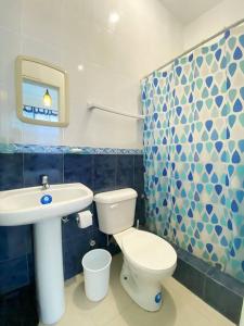 La salle de bains est pourvue de toilettes blanches et d'un lavabo. dans l'établissement Casa frente al mar ideal para grupos y ver el atardecer, à Salinas