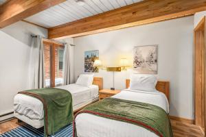 two beds in a room with wooden ceilings at Chateau DuMont 05 in Aspen